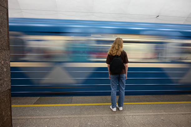 istock a girl with a backpack is waiting for a train at the station 1475565652