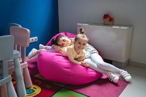 Caucasian sisters, playing at the play corner at the ophthalmology clinic