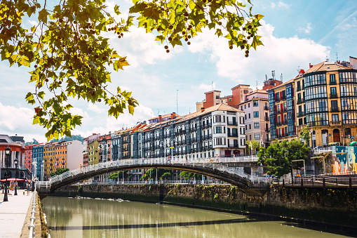 Landscape view of Bilbao downtown with the Nervion river, Ribera bridge and its colorful architecture on a sunny day. Enjoying a nice vacation in the Basque Country, Spain