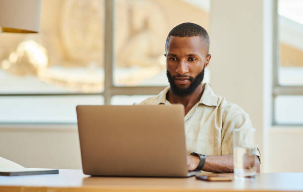 istock Young African man with a laptop computer working from home or office. Home office concept. Stock photo with copy space 1475572686