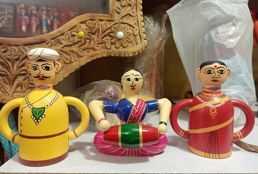 A closeup selective focus Picture of Hand Made Wooden Colorful Channapatna Ring Toys Of Men Playing Traditional Indian Musical Instruments