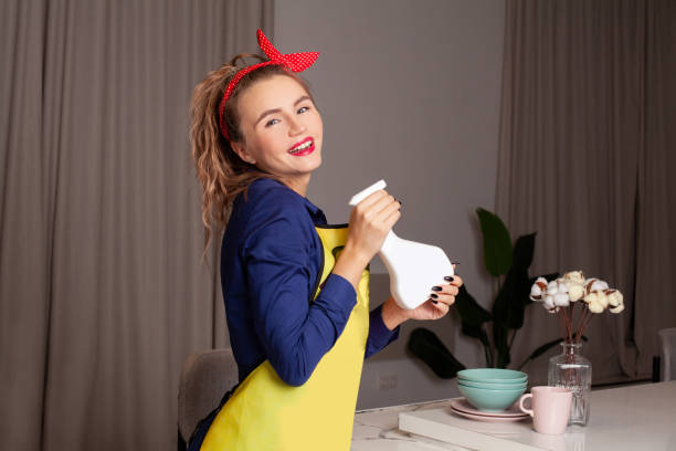 ładna kobieta w stylu vintage. kobieta pin-up z modnym makijażem. retro kobieta sprzątająca kuchnię - stereotypical housewife women domestic kitchen brown hair zdjęcia i obrazy z banku zdjęć