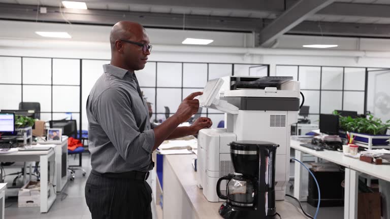 Black businessman at the office photocopying a document