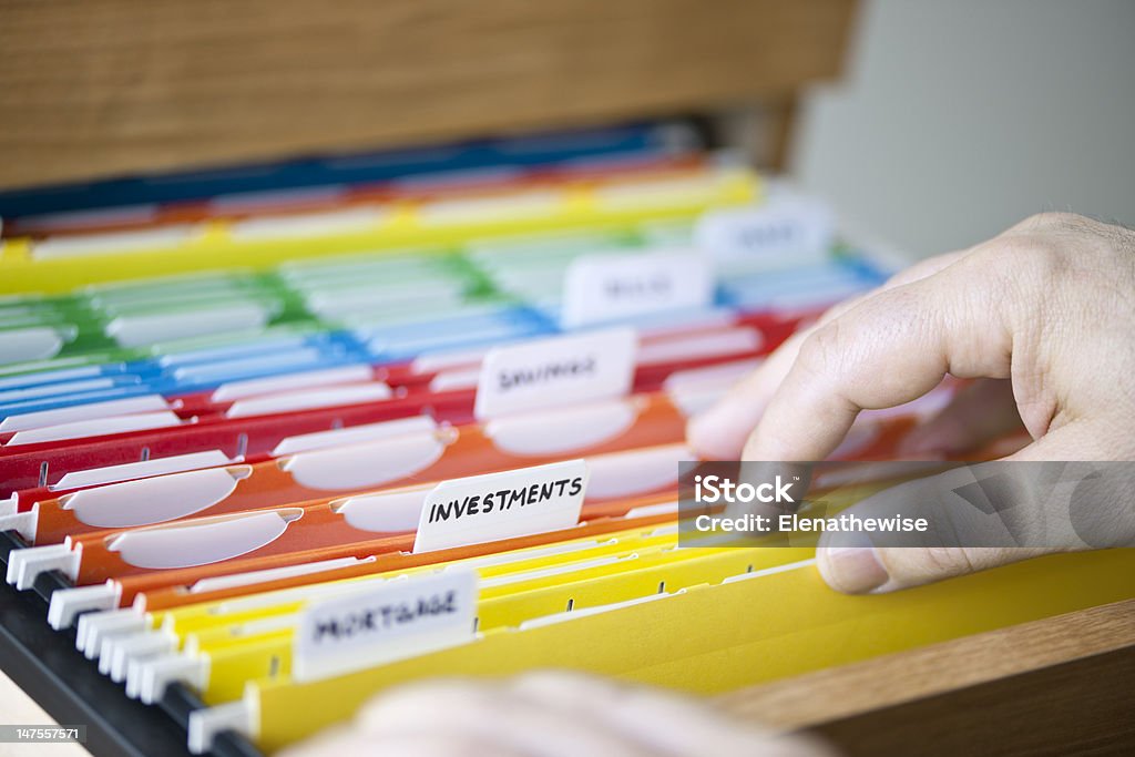 Financial documents in folders Hands searching through file folders with personal finance documents File Folder Stock Photo