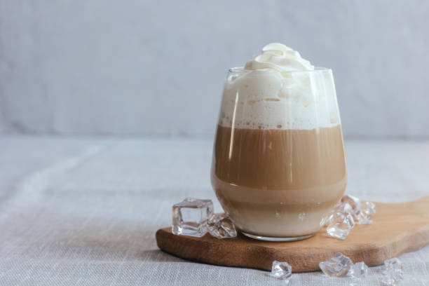 istock Coffee latte on a gray table in bright sunlight and free space. Cold summer coffee with ice. 1475576233