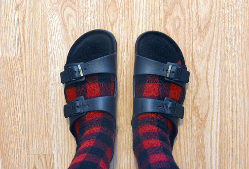 Closeup of a man wearing heavy socks and sandals.