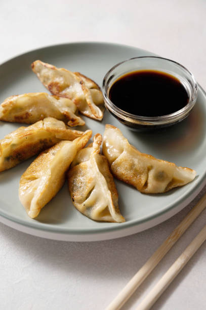 istock Fried dumplings gyoza with soy sauce, and chopsticks. 1475581022