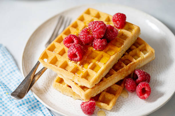istock Breakfast waffles with berries in plate served with cup of tea. 1475581081