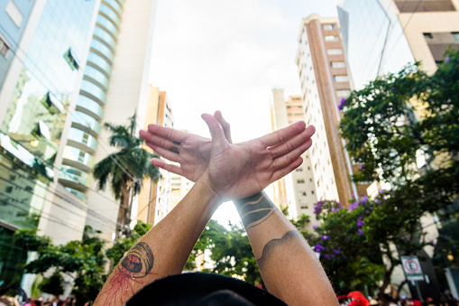 Hands of a young man symbolizing a “pigeon”, a sign for the drums of the Belo Horizonte Carnival block