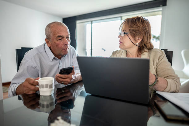 istock Senior couple talking while use a laptop to do home finances 1475586426