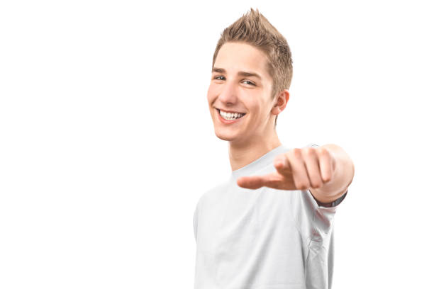 young red-haired man in a beige shirt points his finger to the side on a white background.