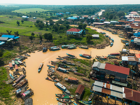 Fishing and tourist boats sail along the yellow river through a floating village on Tonle Sap Lake north of Phnom Penh. The Tonle Sap is Cambodia's biggest lake.