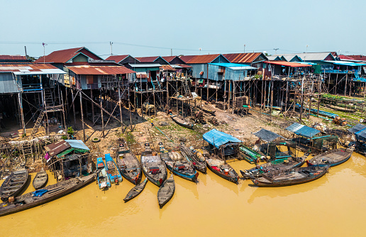 Fishing and tourist boats sail along the yellow river through a floating village on Tonle Sap Lake north of Phnom Penh. The Tonle Sap is Cambodia's biggest lake.