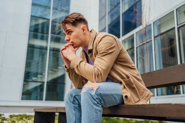 istock Young sad man sitting on the bench in the city 1475590310