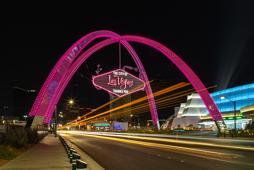 A picture of the Las Vegas Boulevard Gateway Arches at night, with some light painting from nearby traffic.