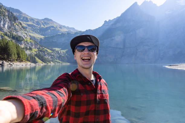 istock Young man takes selfie while hiking around beautiful alpine lake 1475594425