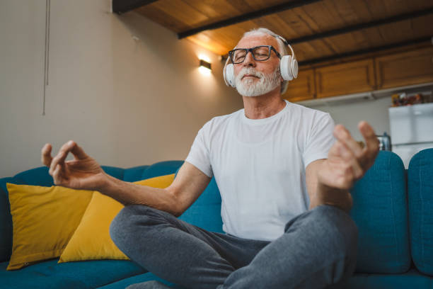 istock One senior man doing guided meditation yoga self care practice at home 1475594785