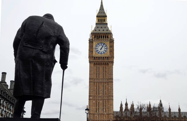 vista posteriore della statua di sir winston churchill che domina il big ben e le houses of parliament a westminster, londra, regno unito. - winston churchill foto e immagini stock