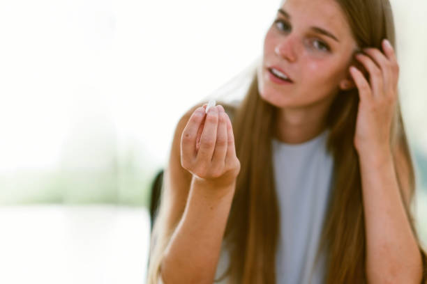 istock woman taking a pill - focus on the hand 1475595561