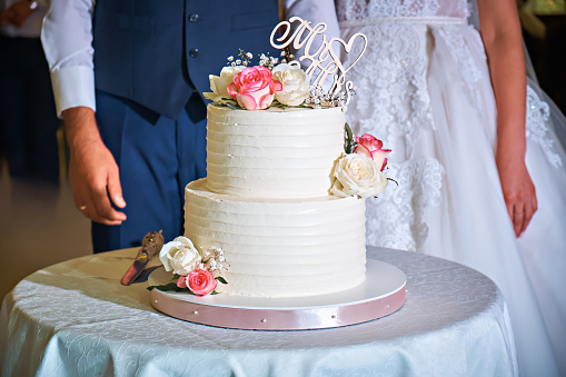 White wedding cake decorated with rose flowers. Wedding theme.