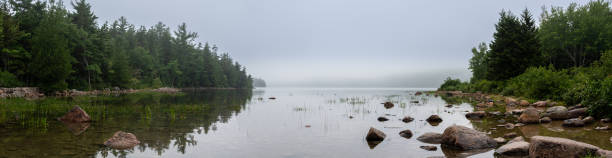 waters edge of jordan pond no parque nacional de acadia, maine, eua com neblina se instalando à distância - treelined forest at the edge of scenics - fotografias e filmes do acervo