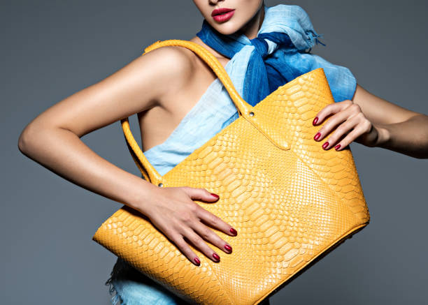 Stylish beautiful  woman wearing blue scarf  with yellow handbag stock photo