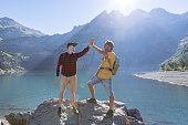 Two hikers celebrating success on top of rock with an high five