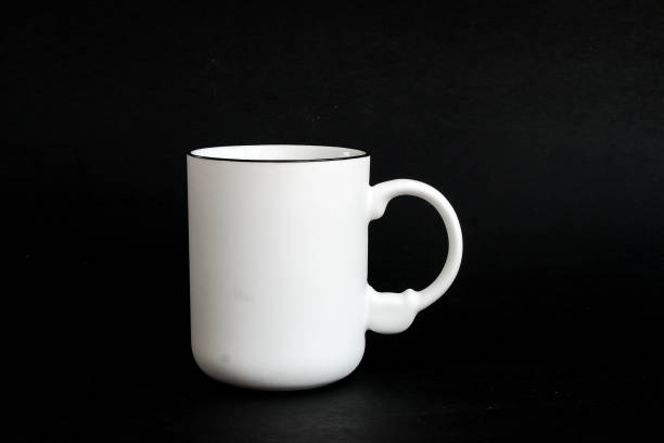 istock White mug. White cup with red heart for tea or coffee on background. 1475602313