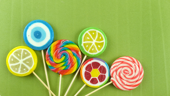 Colorful lollipops on green background