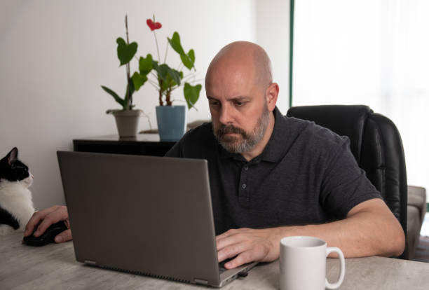 istock Brazilian middle-aged man using a laptop working at home 1475606622