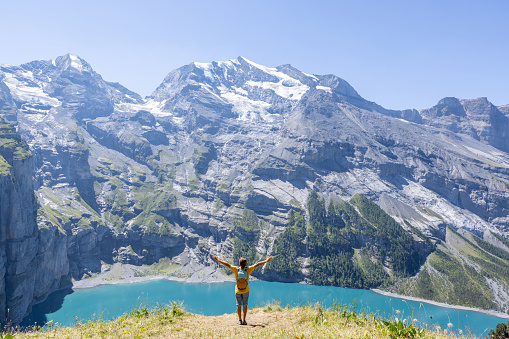 Berner Oberland canton, Switzerland\nHe stands on a rock by a beautiful blue lake in the center of Switzerland.