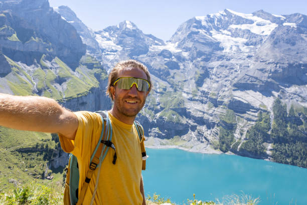 istock Young man takes selfie while hiking around beautiful alpine lake 1475608838