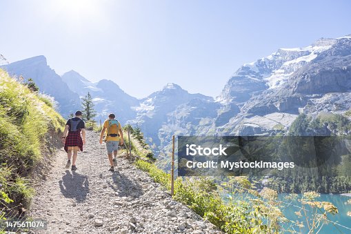 istock Two men hiking in a beautiful alpine scenery in Summer walking in the Swiss Alps enjoying nature and the outdoors 1475611074