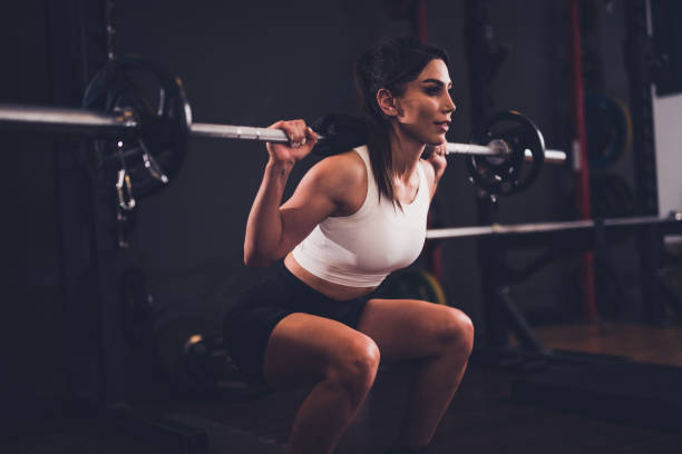 istock Young woman using weights at the gym 1475612133