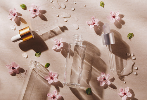 Face serum droppers with flowers and sunlight