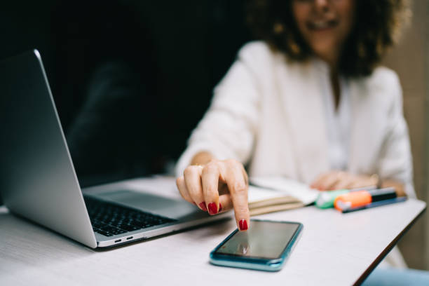 istock Selective focus on modern smartphone device used by unrecognizable female freelancer checking received text email or app notification, blurred woman browsing website on digital mobile technology 1475615733