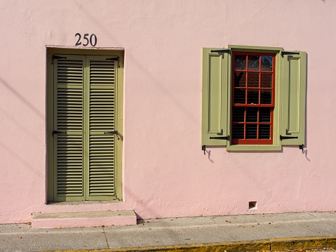 Colorful window and doorway in old town Saint Augustine Florida. Narrow alley way with side of house on edge of street.