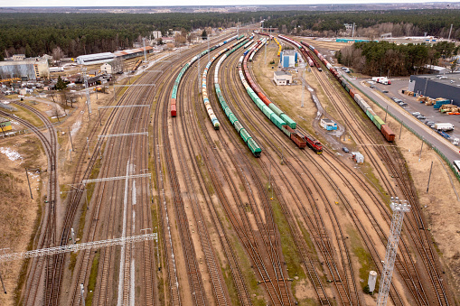 Drone photography of railway depot, cargo carriages and train during winter cloudy day