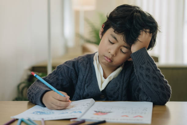 istock Little boy tired stressed of reading, doing homework 1475617341