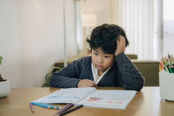 istock Little boy tired stressed of reading, doing homework 1475617349