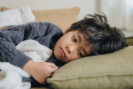 Boy with headache lying on the bed