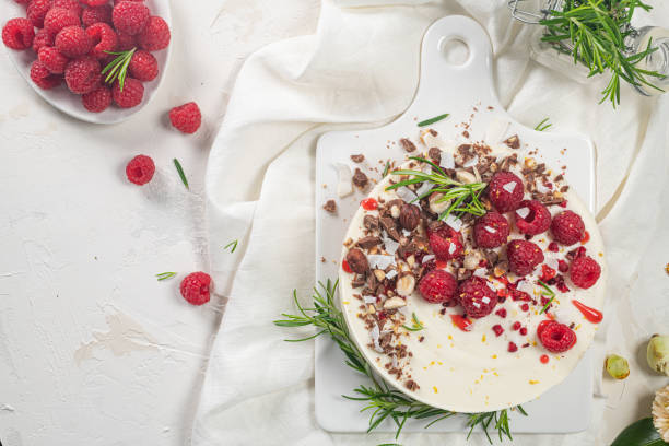 istock Cheesecake with raspberries, chocolate, hazelnuts and rosemary leaves on kitchen coutertop 1475618085