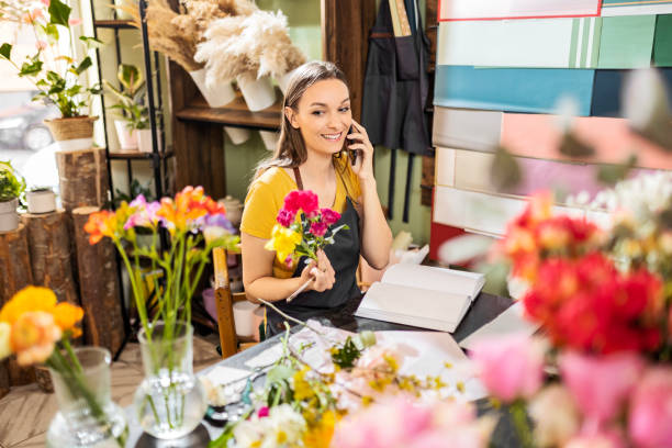 istock Female florist on phone with customer 1475620761