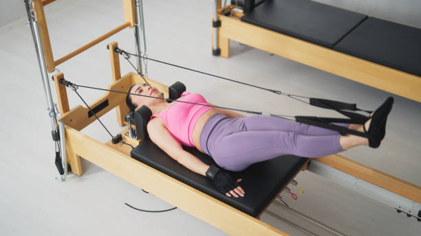 istock Female pilates trainer working out on pilates machine in pilates studio 1475621026