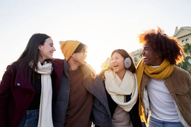 istock Multi-ethnic group happy friends hugging having fun. Cheerful multiracial students outdoors winter. 1475621177