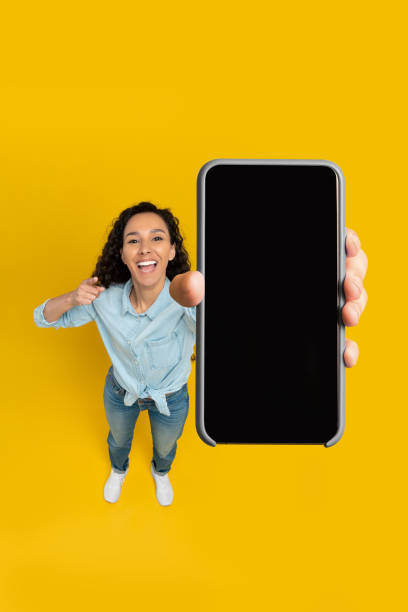 istock Happy lady showing blank mobile phone screen at studio 1475624115