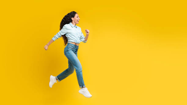istock Joyful Arabic Lady Running In Mid Air Over Yellow Background 1475624132