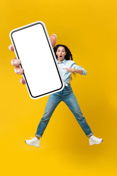 istock Shocked Arabic Lady Showing Phone Screen Over Yellow Background, Vertical 1475624135