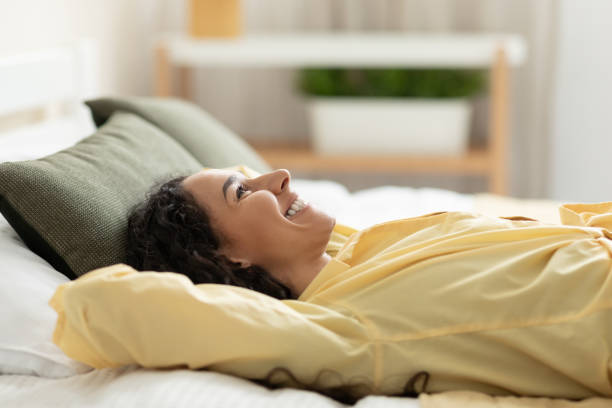 istock Smiling woman having rest at home lying on bed 1475624149