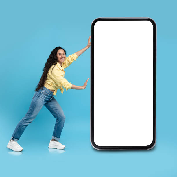 istock Female Pushing Cellphone With Large Empty Screen On Blue Background 1475624226